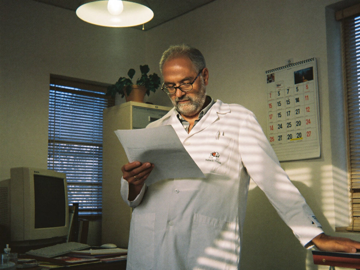 Doctor reading notes in his consulting room Image